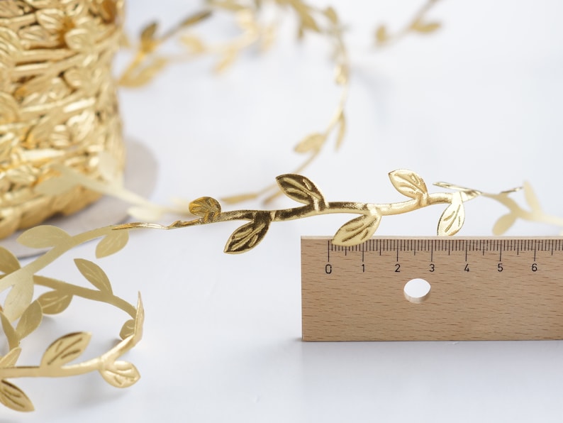 May include: Gold leaf garland with leaves and branches. The garland is 6 inches long.