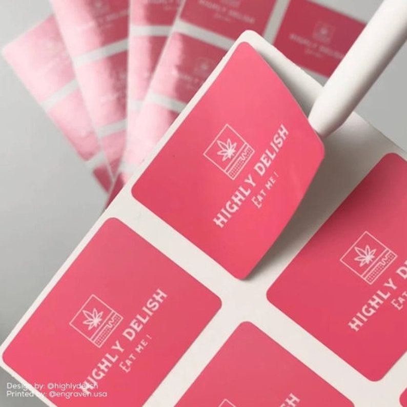 May include: Pink square stickers with a white outline and a white graphic of a marijuana leaf inside a square with the text "HIGHLY DELISH EAT ME!"