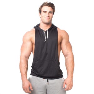 May include: Black sleeveless hoodie with a front pocket and drawstring. The hoodie is paired with gray sweatpants. The outfit is designed for athletic wear and casual comfort.
