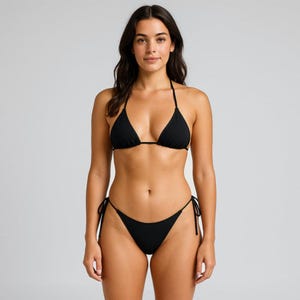 Könnte beinhalten: Schwarzes Bikini-Set mit einem Triangel-Oberteil mit Neckholder-Trägern und einem passenden, tief sitzenden Unterteil. Das Bikini-Set hat Bindebänder an Ober- und Unterteil. Der Badeanzug ist aus glattem, einfarbigem, schwarzem Stoff.