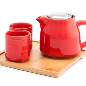 May include: Red ceramic teapot and two cups on a bamboo tray. The teapot has a stainless steel lid.