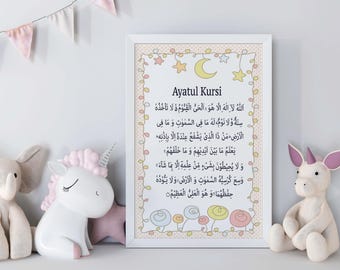 May include: A white framed print with a pink and yellow background. The print features a crescent moon and stars with the Arabic text "Ayatul Kursi" in black. The text is a verse from the Quran.