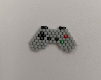 Peut inclure: Une petite manette de jeu en perles grises, noires, vertes et rouges.