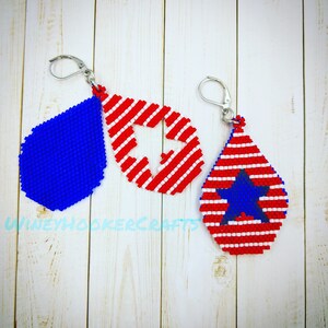 Pode incluir: Três pares de brincos de contas em forma de lágrima. Um par é azul sólido, um par é vermelho e branco com uma estrela branca e um par é vermelho e branco com uma estrela azul.