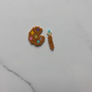 May include: A brown and gold beaded palette with colorful beads and a brown and gold beaded paintbrush.