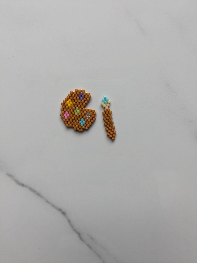 May include: A brown and gold beaded palette with colorful beads and a brown and gold beaded paintbrush.