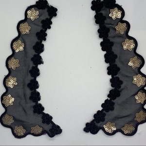 May include: Two black lace trims with gold sequin embellishments. The trim has a scalloped edge and a floral design.