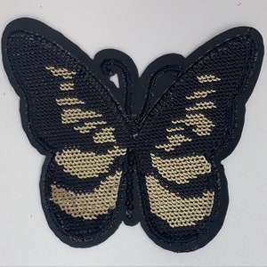 May include: Black and gold butterfly-shaped patch with sequins.