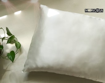 May include: A white pillowcase with a smooth, silky texture. The pillowcase is lying flat on a white surface.