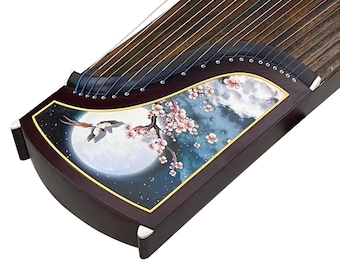 Puede incluir: Un Guzheng de madera marrón oscuro, un cítara chino tradicional, con un diseño decorativo de un pájaro volando sobre una luna llena y una rama de árbol en flor. El instrumento tiene 21 cuerdas y está decorado con un borde dorado.