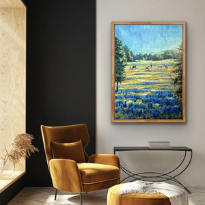 May include: A rectangular framed wall art print featuring an oil painting of a vibrant field of bluebonnets and wildflowers under a bright blue sky, with several horses grazing in the distance between two large green trees.