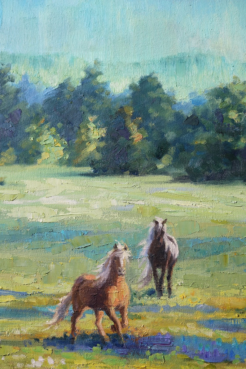 May include: An oil painting on canvas depicting two horses in a grassy field. One horse is light brown with a white mane, and the other is darker brown. The background features a dense line of green trees under a pale blue sky.