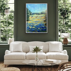 May include: A framed landscape painting featuring a vibrant field of bluebonnets in the foreground, transitioning into a grassy meadow with several horses grazing under a bright blue sky, framed in a simple white border.