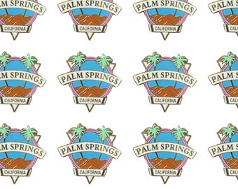 May include: A repeating pattern of gold, blue, pink, and green enamel pins with the text "PALM SPRINGS CALIFORNIA" in a retro style.