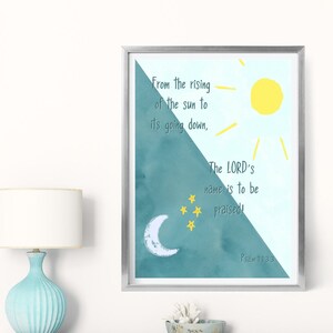 Op de afbeelding: Een ingelijste print met een zilveren rand, met een aquarelontwerp van een zon, maan en sterren. De tekst luidt: "Van de opgang van de zon tot haar ondergang, de naam des HEREN zij geprezen!" Psalm 113:3 staat onderaan afgedrukt.