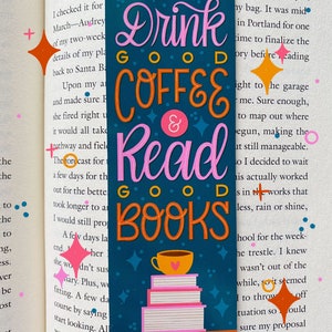 May include: A teal blue bookmark with pink and orange lettering that reads "Drink Good Coffee & Read Good Books". The bookmark features a stack of books and a coffee cup with a heart on it. The background is a dark blue with white stars.