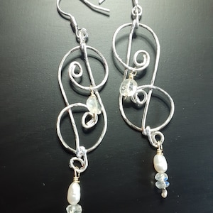 Silver spiral shaped hammered wire earring represents stylized zodiac sign Cancer symbol. Moonstone and pearl gems. Silver plated ear wire.