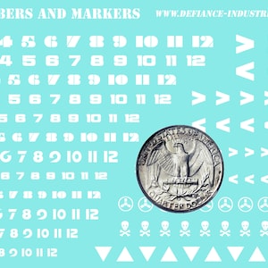 May include: A sheet of white vinyl stickers with numbers 0-12, arrows, skulls, and other symbols on a light blue background. The text "WHITE NUMBERS AND MARKERS" is at the top of the sheet.