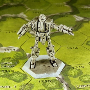 Könnte beinhalten: Ein weiß bemalter Miniaturroboter mit einer Waffe, der auf einem sechseckigen Sockel steht, auf dem die Zahlen 1215, 1315 und 1314 aufgedruckt sind. Der Roboter hat einen großen Kopf mit einem runden Auge und einer kleinen Antenne. Der Roboter steht auf einer grün-braunen Oberfläche mit den Worten "Level 1 Light" aufgedruckt.