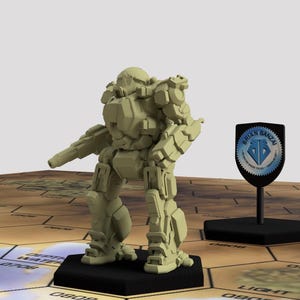 May include: A beige plastic miniature of a robot or mech, standing on a black base. The robot has a large head with a visor and a large gun in its right hand. The robot is standing on a hexagonal tile with the text "DEATH STAR" printed on it. The robot is standing on a table with a brown wooden surface.