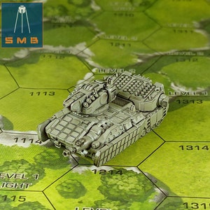 Puede incluir: Un tanque en miniatura gris, detallado, con una torreta grande y múltiples cañones. El tanque está sentado en un tablero de juego hexagonal verde con números impresos en cada hexágono.