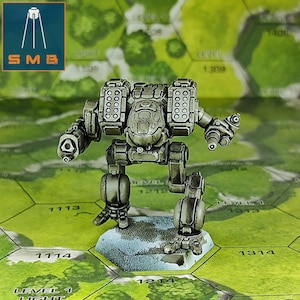 Può includere: Un robot mech in miniatura grigio metallizzato, in piedi su una scacchiera esagonale. Il robot ha armi e armature dettagliate. La scacchiera presenta un paesaggio verde e beige con sezioni di griglia numerate. Il logo "SMB" si trova nell'angolo in alto a sinistra.