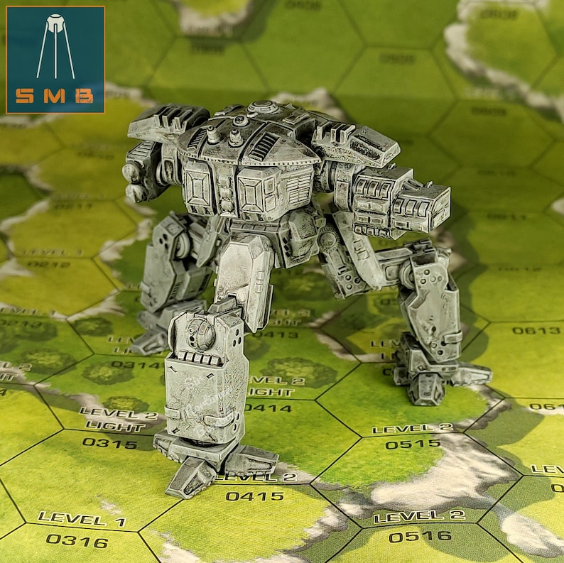 May include: A gray, miniature mech robot with detailed paneling and weaponry stands on a green and tan hexagonal grid. The robot has a weathered appearance. The logo "SMB" is in the upper left corner.