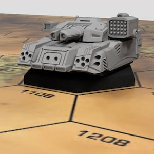 Op de afbeelding: Een grijs, futuristisch ogend tankmodel met een groot kanon en meerdere kleinere kanonnen op de bovenkant. De tank staat op een zwarte zeshoekige basis.