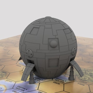 May include: A gray, spherical, futuristic-looking object with a textured surface and multiple small, round openings. The object has three legs that extend out from the bottom, each with a flat, rectangular panel.