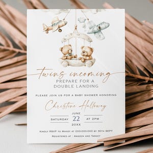 May include: A baby shower invitation with a vintage airplane and teddy bear theme. The invitation features the text "Twins incoming, prepare for a double landing." The date is June 22nd at 2 PM. The invitation is registered at Amazon and Target.