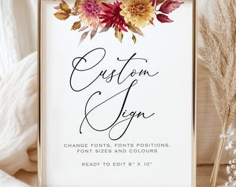 May include: A framed sign with the words "Custom Sign" in elegant script. The top of the sign is decorated with a floral arrangement in shades of burgundy, yellow, and brown. The sign is 8" x 10" and ready to edit.