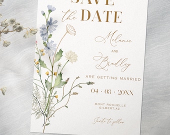 May include: A white invitation card with gold text that reads "Save the Date" and details for a wedding. The card is decorated with watercolor flowers in shades of blue, yellow, and green.
