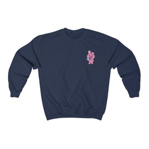 Puede incluir: Una sudadera azul marino con un conejo rosa sosteniendo un micrófono azul en el pecho izquierdo.