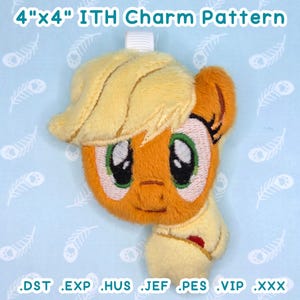Puede incluir: Un charm de peluche con forma de poni de dibujos animados con melena y sombrero amarillos y cuerpo naranja. El charm mide aproximadamente 10 cm por 10 cm. El texto "4"x4" ITH Charm Pattern" está en la parte superior.