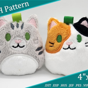 May include: Two plush cat toys, one grey and one white with orange and black patches. Both have green eyes and pink noses. The toys are 4 inches by 4 inches and are labelled "ITH Pattern".