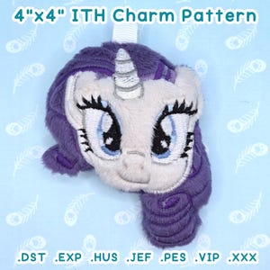 May include: A plush unicorn charm with a white face, blue eyes, and purple mane and tail. The charm is approximately 10 cm by 10 cm and has the text "4"x4" ITH Charm Pattern".