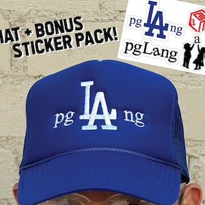 May include: A blue trucker hat with the text "LA pgLang" in white. The hat has a mesh back and a curved brim. The image also includes a sticker pack with various "pgLang" designs and the text "HAT + BONUS STICKER PACK!"