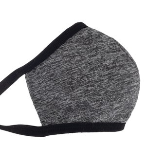 May include: A gray and black face mask with a black elastic band. The mask is made of a soft, breathable fabric.