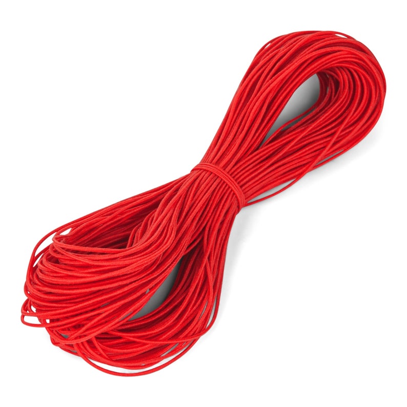 May include: A bundle of bright red elastic cord, tightly wound and secured. The cord is smooth and appears to be made of a synthetic material. The image is set against a clean white background, highlighting the vibrant color and texture of the cord.