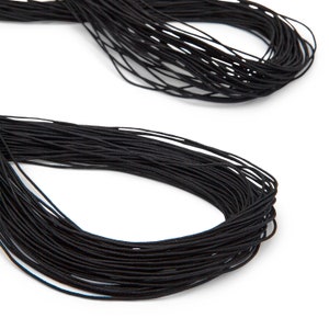 May include: Two bundles of black elastic cord against a white background. The cords are tightly wound, with a slightly glossy appearance. The image is a close-up, highlighting the texture and color of the material, suitable for crafting or sewing projects.