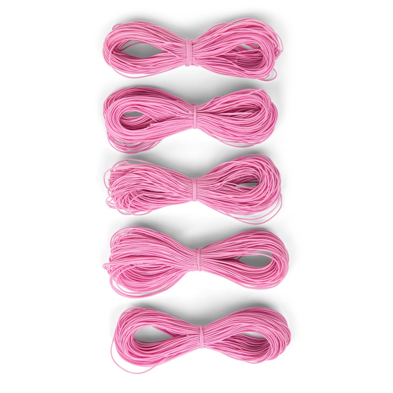May include: Five spools of pink elastic cord, arranged vertically in a row. Each spool is tied in a bow shape.