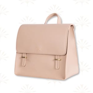 May include: A blush-colored backpack with a flap closure and a top handle. The bag features gold-colored hardware on the front straps and a small logo near the top. The design is minimalist and stylish, suitable for everyday use.