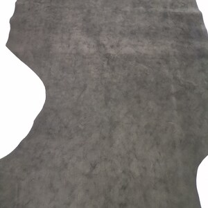 May include: A piece of dark gray leather with a textured surface.
