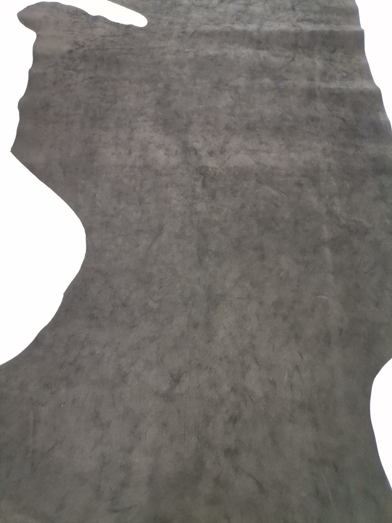 May include: A piece of dark gray leather with a textured surface.