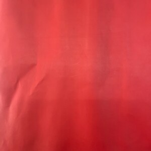 Puede incluir: Una pieza de cuero roja s&oacute;lida. El cuero es liso y tiene un ligero brillo.