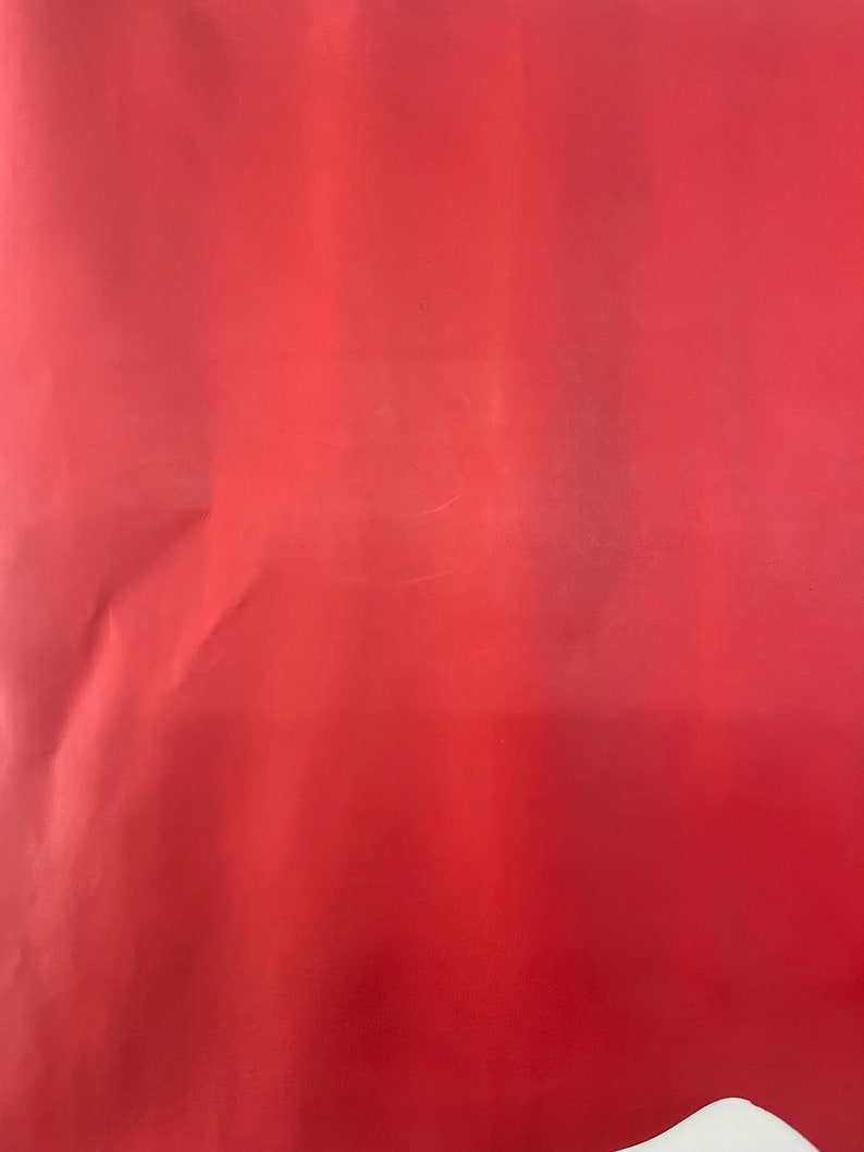 Puede incluir: Una pieza de cuero roja s&oacute;lida. El cuero es liso y tiene un ligero brillo.