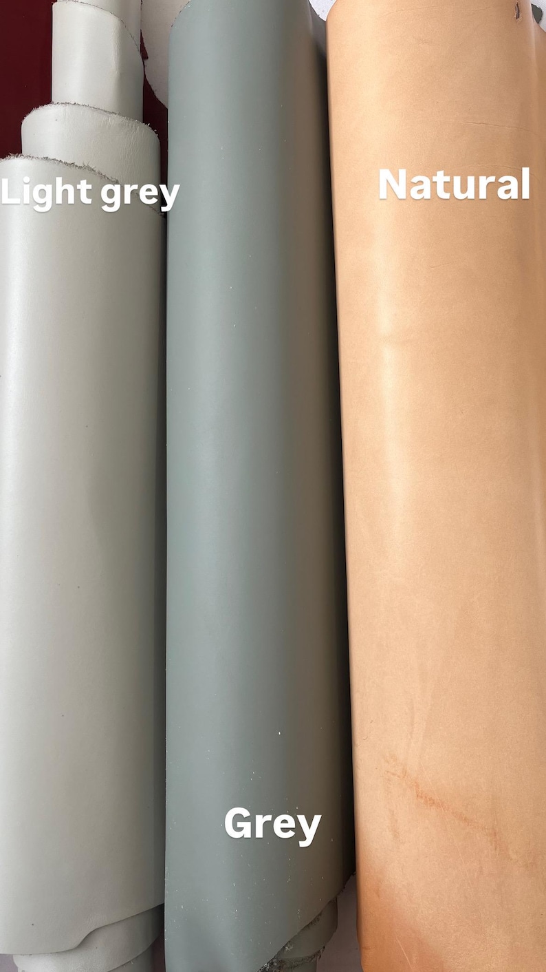 Puede incluir: Tres rollos de cuero en diferentes colores: gris claro, gris y natural. El cuero est&aacute; enrollado y los extremos son visibles.