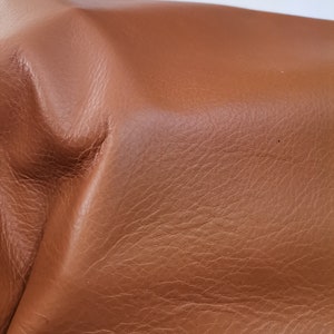 Peut inclure: Gros plan sur un mat&eacute;riau en cuir brun avec une surface textur&eacute;e.