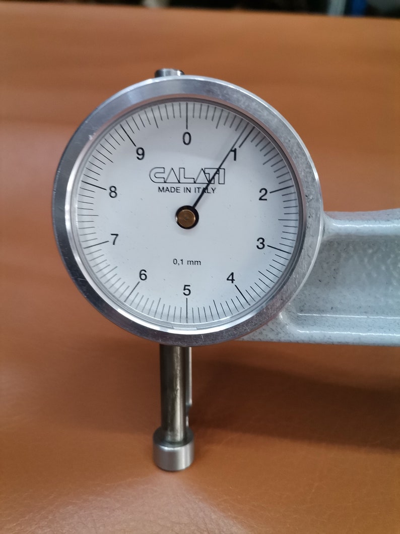 Peut inclure: Une jauge &agrave; cadran argent&eacute;e avec un cadran blanc et des marques noires. La jauge indique 0,1 mm et porte l'inscription "CALAVI MADE IN ITALY" sur le cadran.