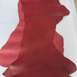 Puede incluir: Una pieza grande de cuero rojo con una superficie ligeramente texturizada.